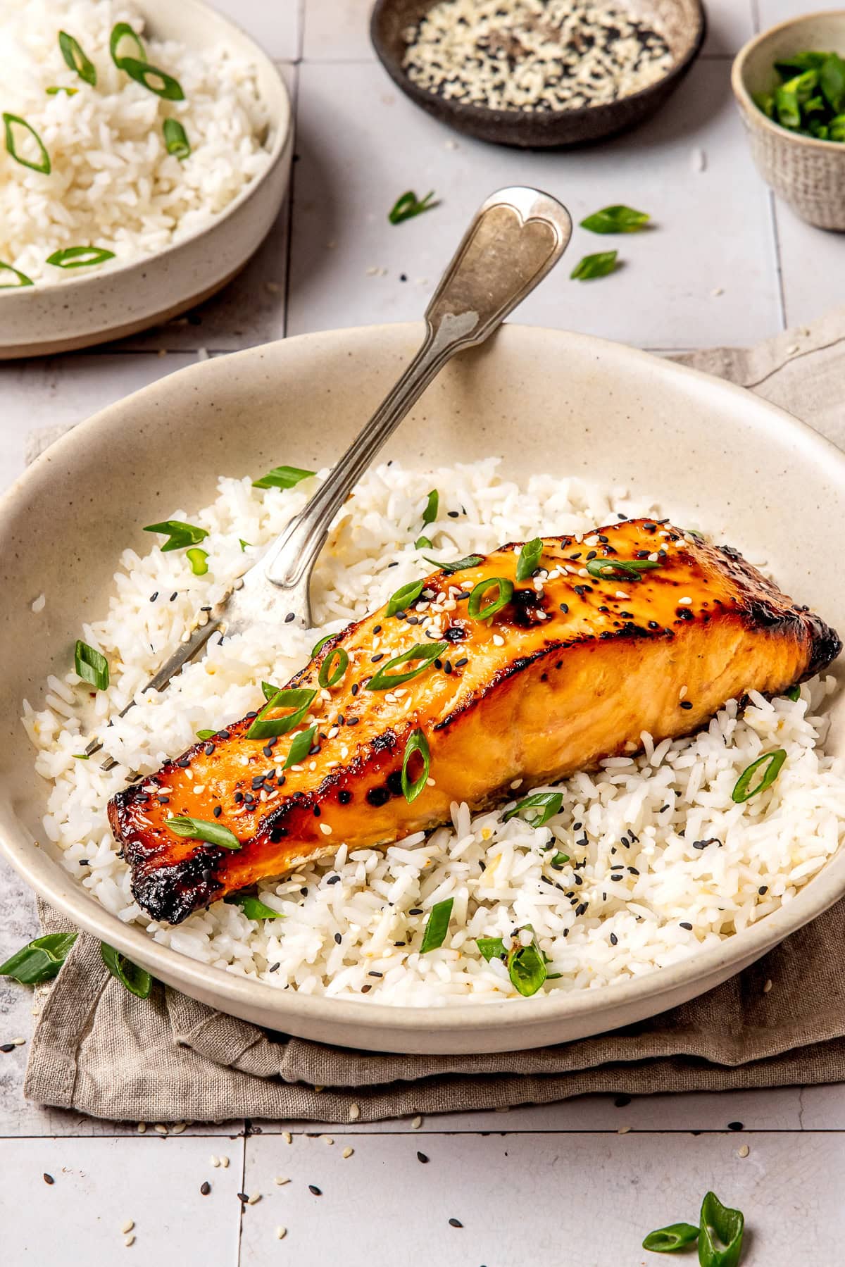 miso glazed salmon served over rice in a bowl with a fork