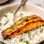 miso glazed salmon served over rice in a bowl with a fork