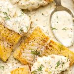 pan seared cod fillets with lemon dill cream sauce on an oval shaped plate