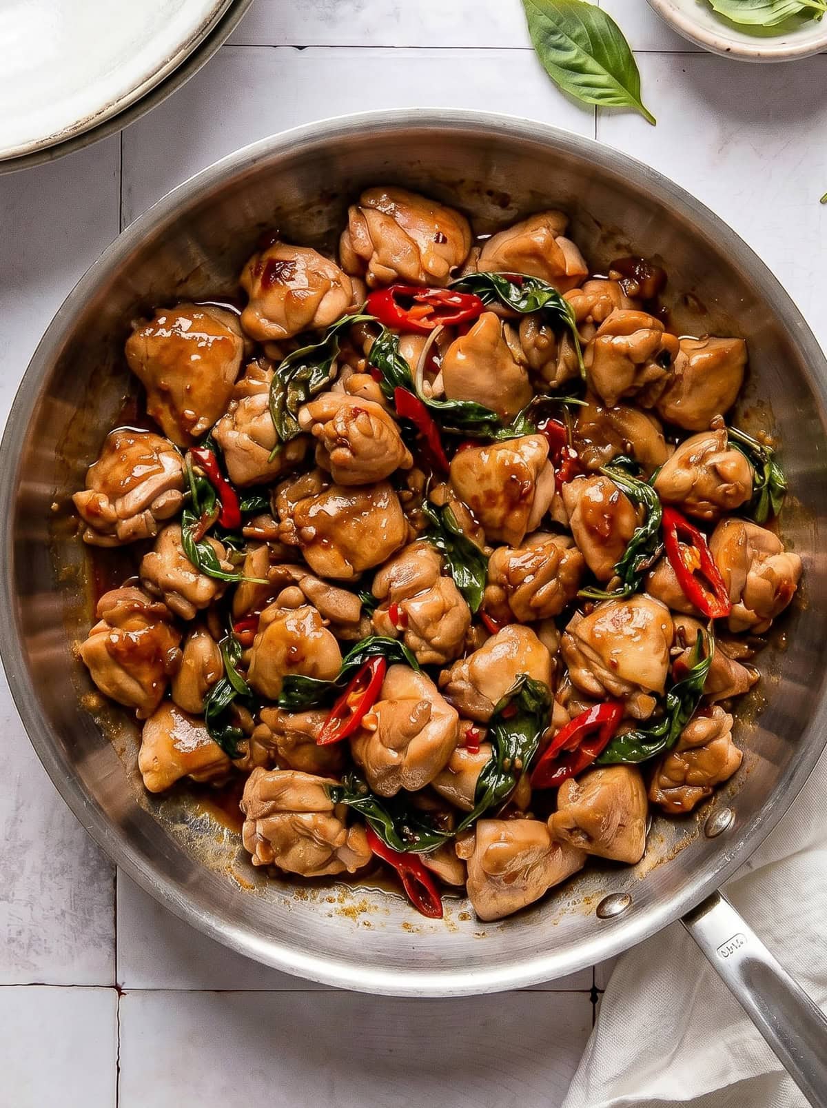 Thai basil chicken in a stainless steel pan