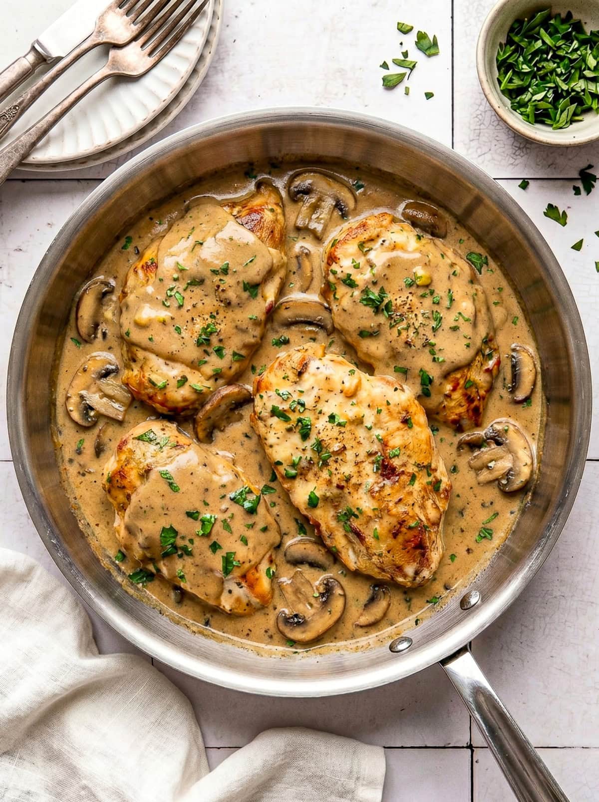 chicken marsala garnished with chopped parsley in a pan