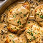 chicken marsala garnished with chopped parsley in a pan