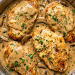 chicken marsala garnished with chopped parsley in a pan