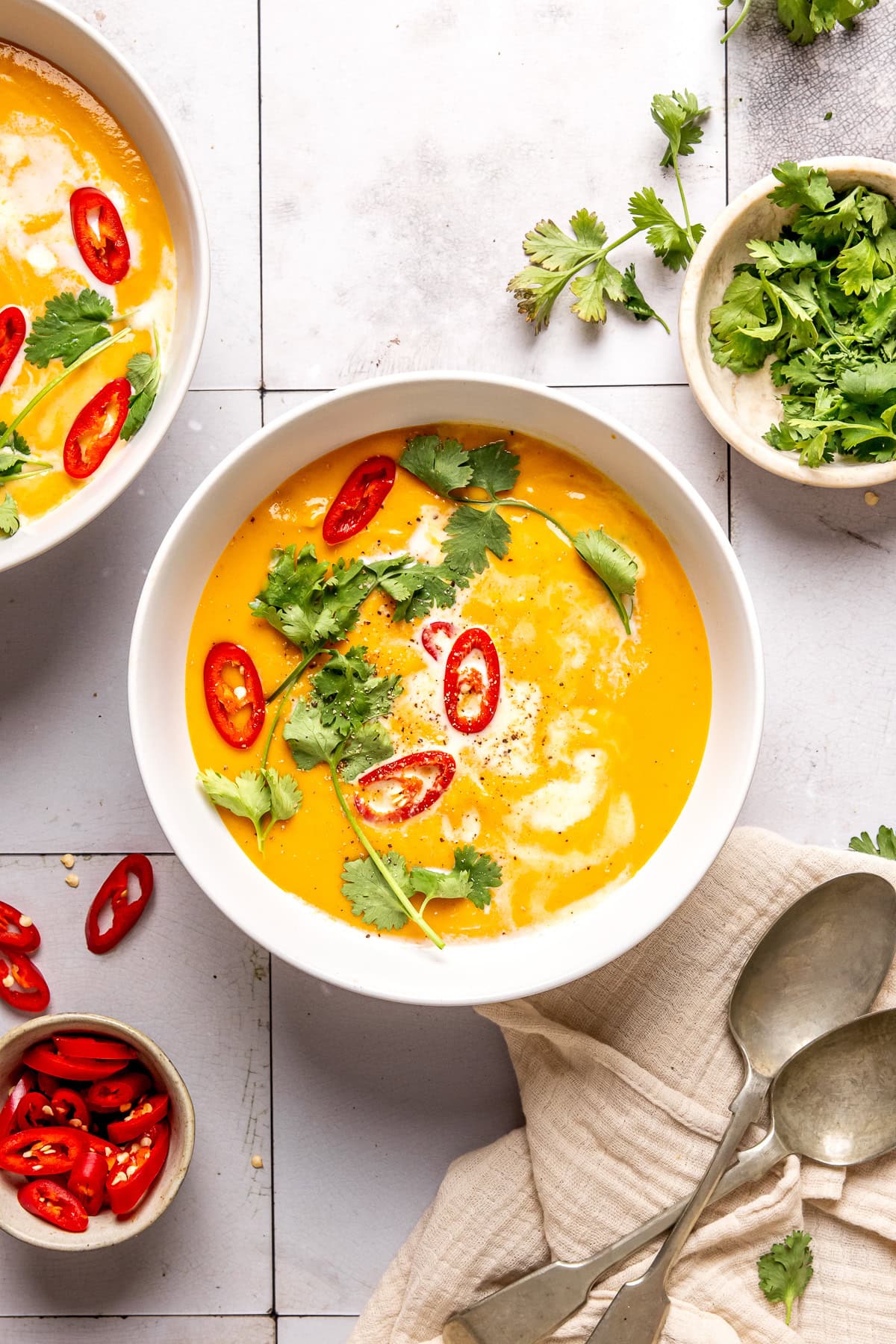 coconut curry pumpkin soup in a bowl garnished with red chili slices and cilantro
